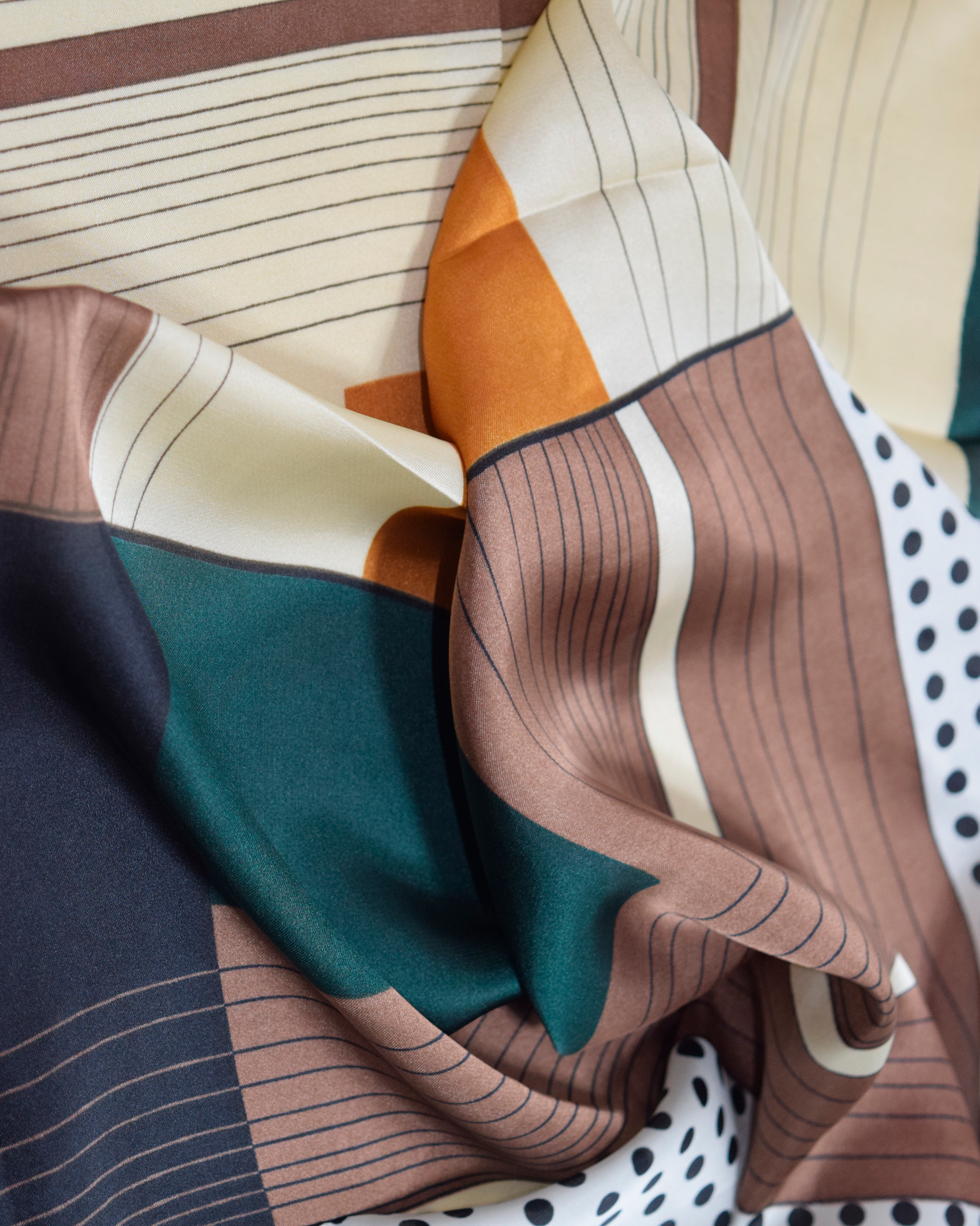 Pañuelo con diseño gráfico y detalles artísticos, fabricado en poliéster