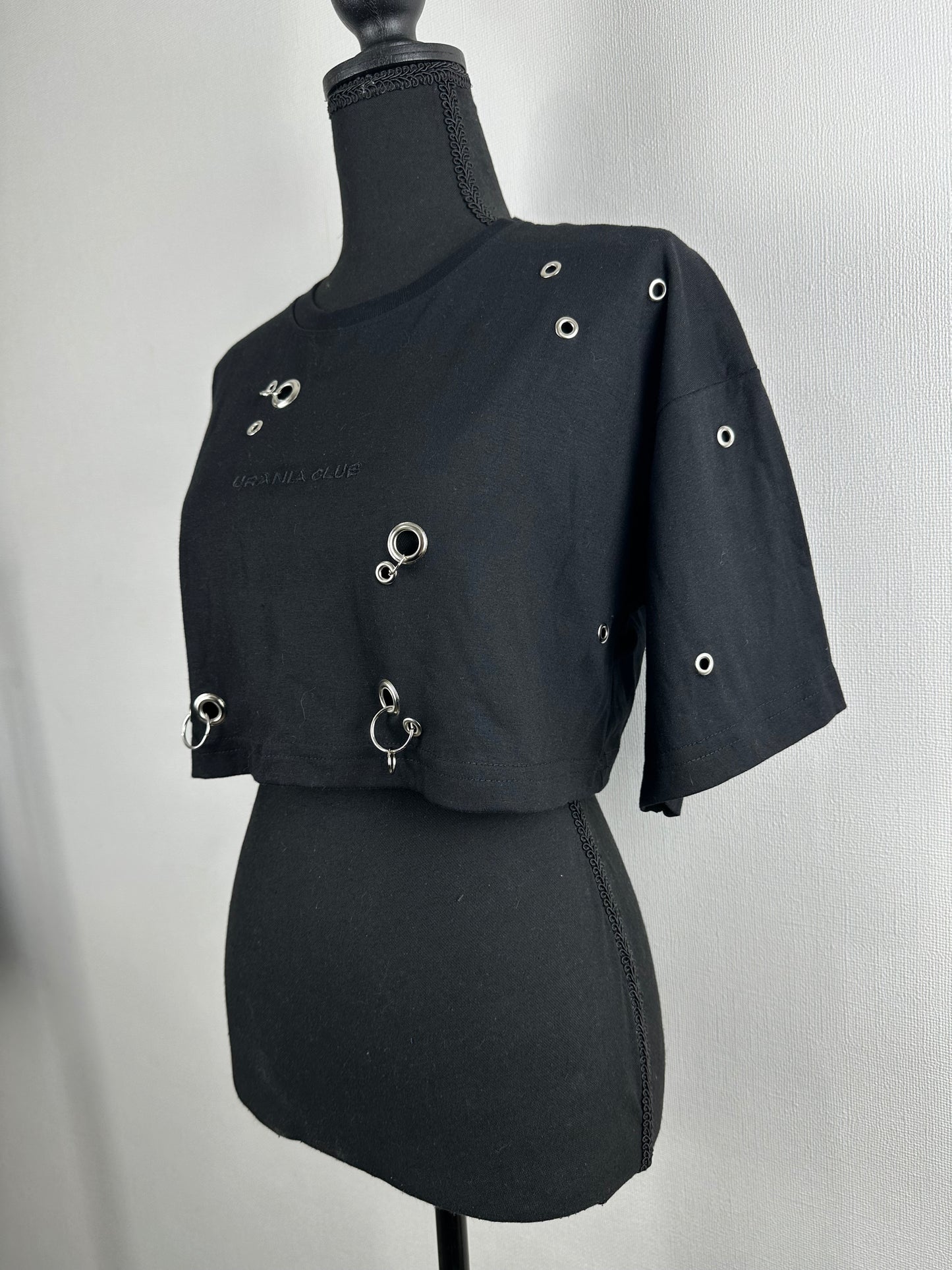 Diseño crop negro con ojetillos y argollas metálicas distribuidas en toda la prenda - Urania Club