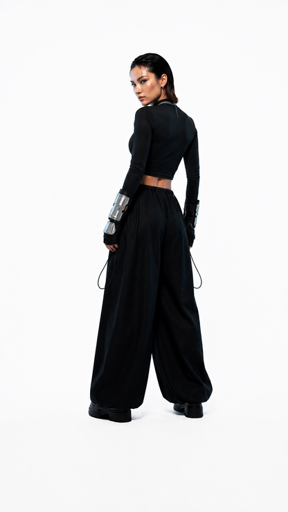 Detalle de caída amplia y volumen oversized en pantalón negro confeccionado en tela Bristech - Urania Club