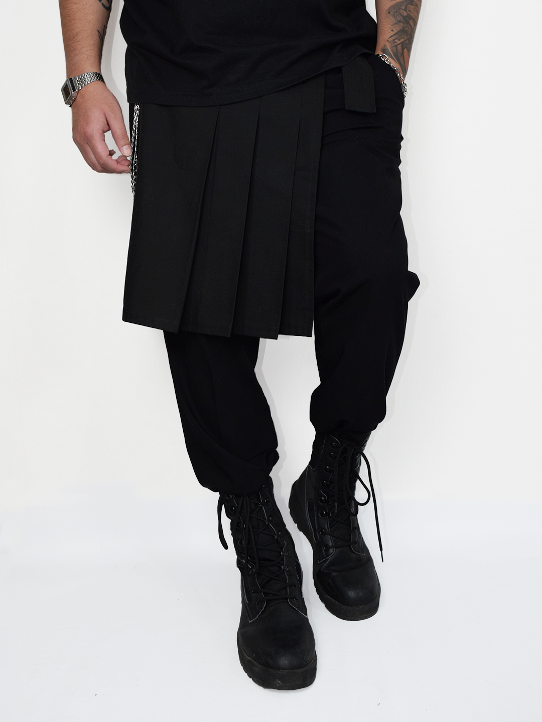 Kilt lateral negro industrial para hombre estilo metal y utility usado sobre pantalón negro