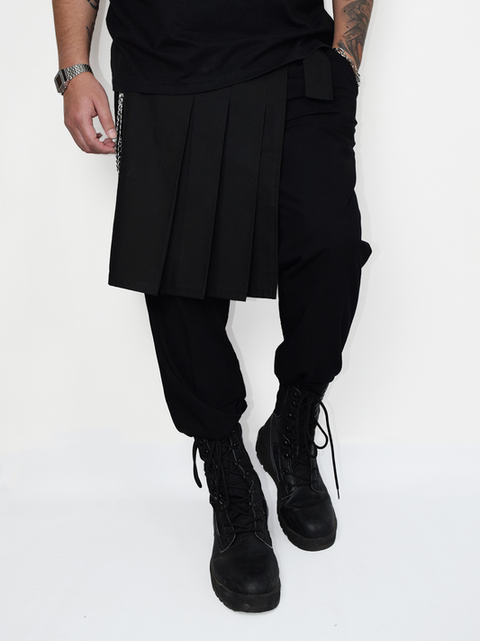 Kilt lateral negro industrial para hombre estilo metal y utility usado sobre pantalón negro