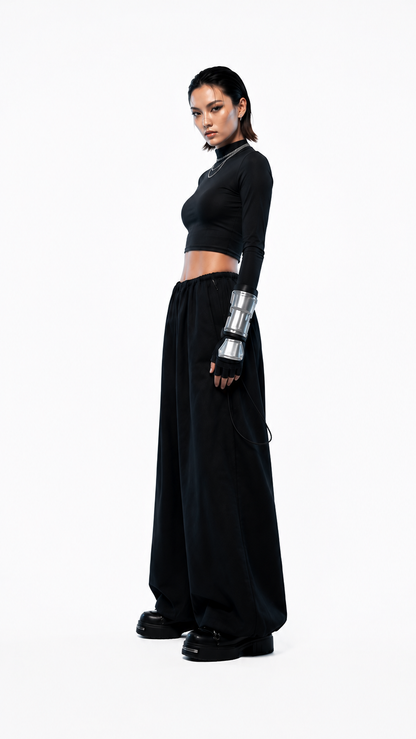 Vista trasera de pantalón oversized negro confeccionado en tela Bristech con caída amplia y ajuste elasticado - Urania Club