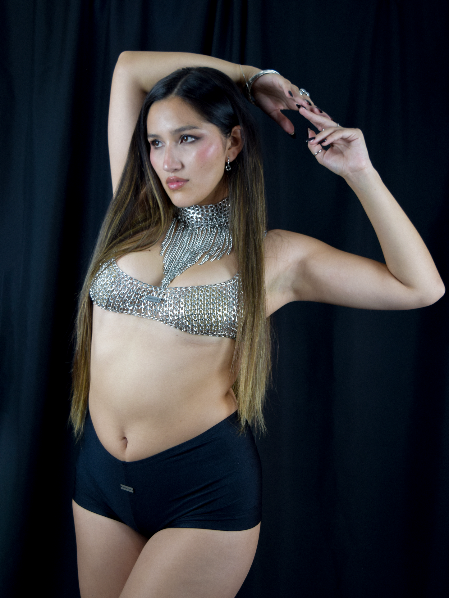 Top de cadenas estilo rave oscuro con caída metálica brillante y estética urbana nocturna - Urania Club
